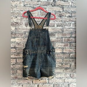 Jean shortfalls slighted distressed, pockets and adjustable straps. Super cute